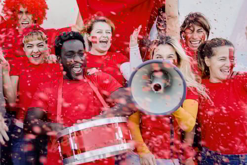 Preview: Multiracial sport football fans celebrate red team victory with confetti in championship at stadium