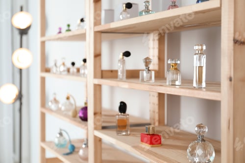 Preview: Different perfume bottles on wooden rack indoors