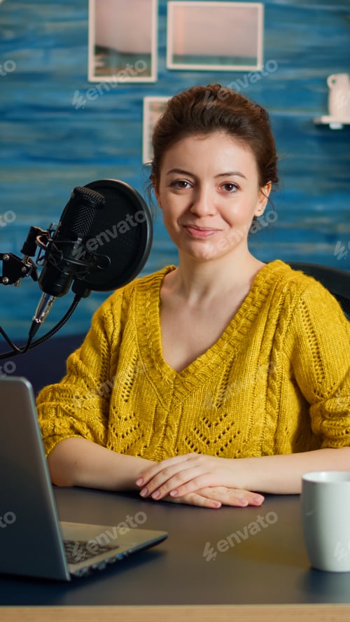 Preview: Portrait of young vlogger working in cozy studio, smiling at camera