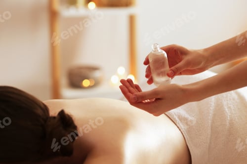 Preview: Woman receiving back massage with oil in spa salon, closeup