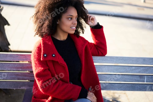 Preview: Smiling woman sitting on wooden bench