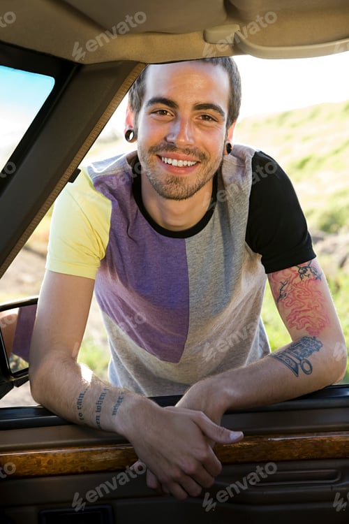 Preview: Man smiling from the driver's seat on a sunny day
