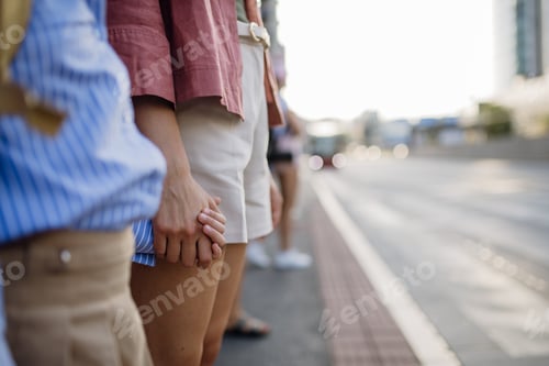 Preview: Mother and school girl with a backpack holding hands while crossing a busy road.