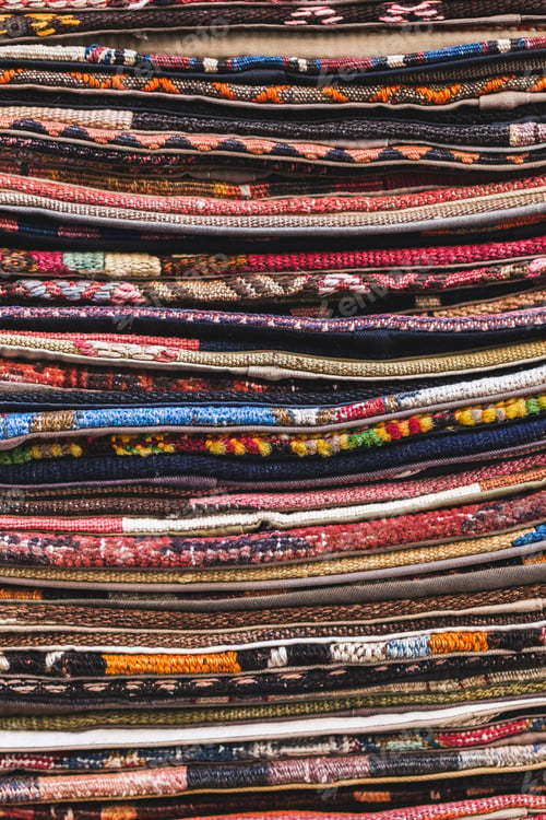 Preview: Pile of beautiful handmade carpets on the market in Istanbul Grand Bazaar. Multicolor background