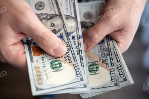 Preview: Close up male hand Counting and holding money us dollar.