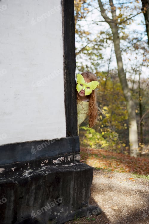 Preview: Girl wearing butterfly mask outdoors