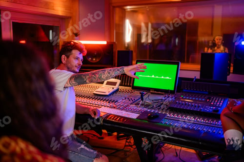 Preview: Music technician raised hand during recording of a vocal track in music studio.