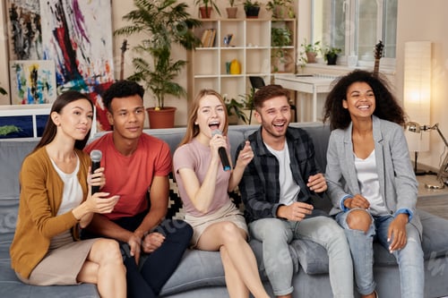 Preview: Cherish the moments. Happy multicultured friends singing with microphone while playing karaoke at