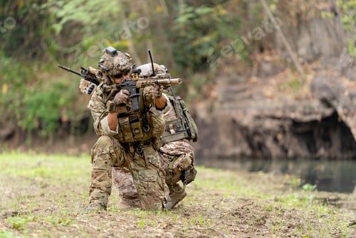 Preview: Two militaries or soldiers stay in battlefield near the river with sit down and point gun