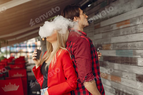 Preview: Stylish young couple with vape in a city