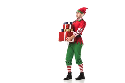 Preview: man in christmas elf costume carrying pile of presents isolated on white