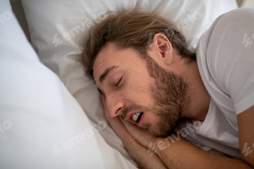 Preview: Relaxed man sleeping deeply in his bed