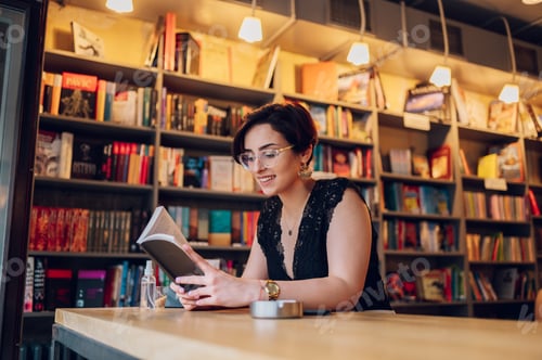 Preview: Woman reading a book while relaxing in the cafe or a bookstore