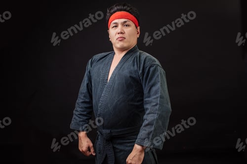 Preview: Fat karate fighter posing to the camera. boss in karate