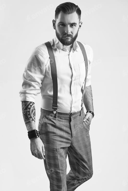 Preview: Portrait Of Brutal Elegant Man In Gray Classic Pants And Suspenders Isolated On White Background In