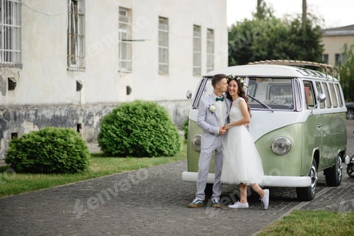 Preview: Hipster bride and groom are standing near their retro bus.