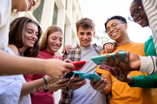 Preview: Group of multiracial generation z young smile happily watching funny videos on a smart phone