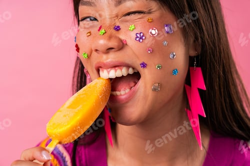 Preview: Beautiful asian woman portrait, young asian woman enjoying popsicle with colorful face gems