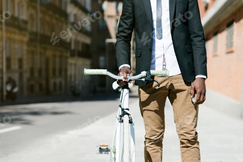 Preview: Handsome african man on bike in the city.