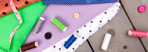 Preview: Banner of Items for sewing clothes. Sewing buttons, spools of thread and cloth.