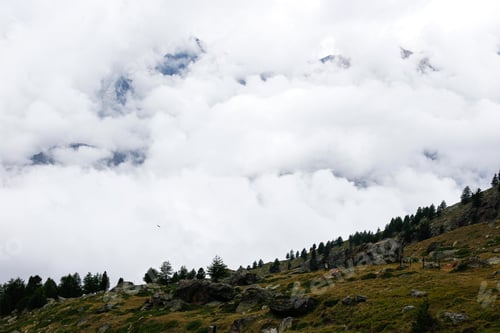 Preview: Alpine scene with clouds among the mountains.