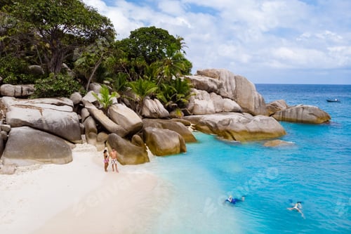 Preview: Young couple men and woman at a tropical beach in the Seychelles Cocos Island, drone view