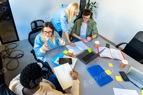 Preview: Diverse group of young business people working on new project together in office.