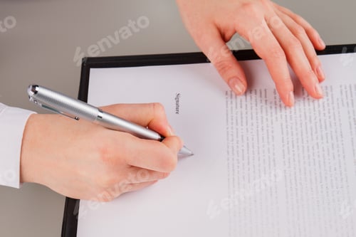 Preview: Business woman signing contract document in office.