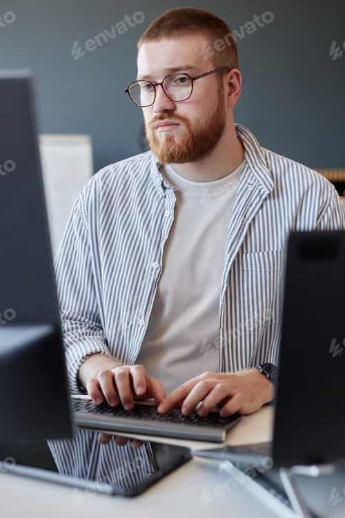Preview: Concentrating on Work at Computer Desk in Office Setting