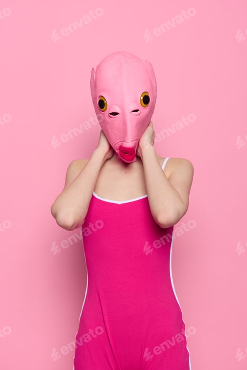 Preview: Woman in a fish costume for Halloween poses against a pink background in a crazy scary costume with