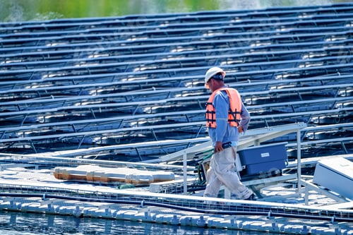 Preview: Local worker working at floating solar panels platform on the water of solar cell power plant.