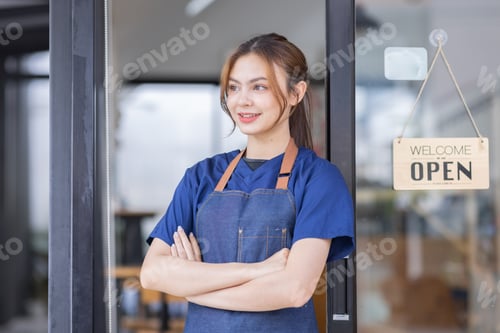 Preview: Shot of smiling young cafe show owner Asian woman is a waitress in an apron standing