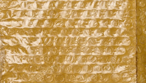 Preview: Texture of yellow paper with film and air bubbles, packaging material for transportation.