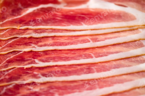 Preview: Sliced italian prosciutto background. Top view, copy space. Prosciutto texture close up