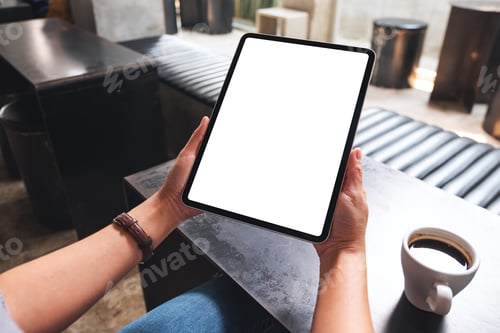 Preview: Mockup image of a woman holding digital tablet with blank white desktop screen in cafe