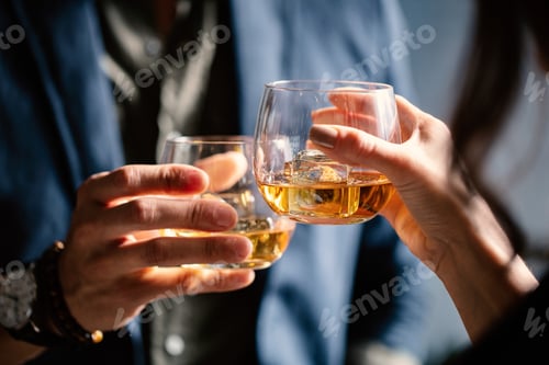 Preview: Closeup shot of two people clinking glasses with alcohol at a toast