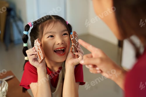 Preview: Gingerbread Delight. Child joyfully presenting decorated cookies during holiday baking.
