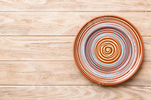 Preview: Top view of empty colorful plate on wooden background. Empty space for your design