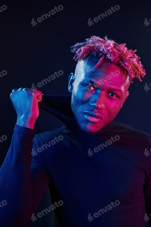 Preview: Futuristic neon lighting. Young african american man in the studio
