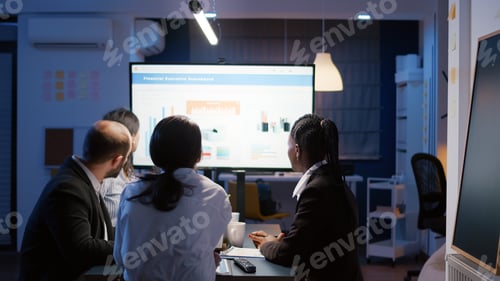 Preview: Businesswoman explaining financial graphs using presentation monitor overworking in office