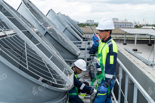 Preview: Engineers inspecting HVAC cooling systems on rooftop