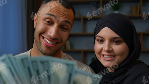 Preview: Rich multiracial couple spouses African American man counting money dollars with Arabian muslim