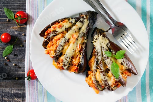 Preview: Baked eggplant with cheese, tomatoes and chicken on a dark wooden table, top view.