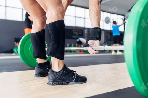 Preview: Cropped view of woman weightlifting barbell in gym