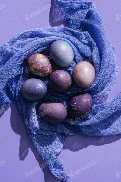 Preview: top view of traditional painted eggs on gauze, on purple