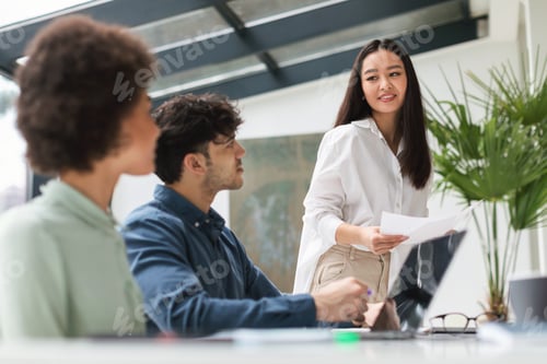 Preview: Japanese Businesswoman Holding Papers During Corporate Meeting In Modern Office