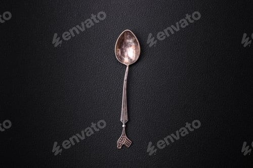 Preview: Empty metal spoon on dark textured concrete background
