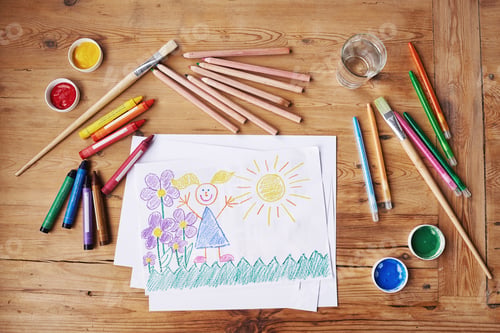 Preview: Shot of a drawing with painting supplies and pencils on a wooden table