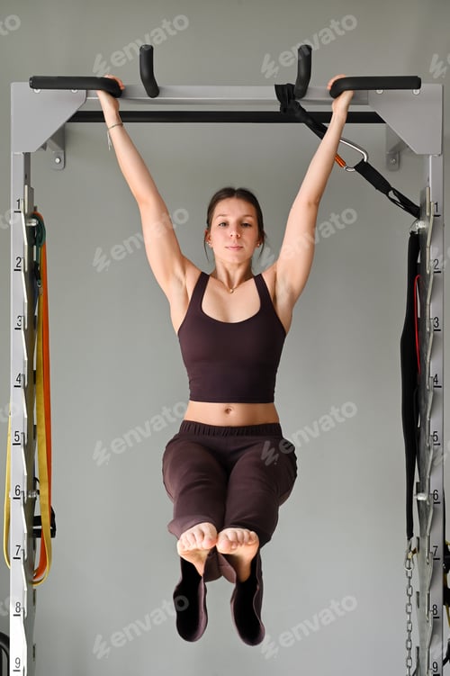 Preview: Young woman performing hanging leg raise exercise