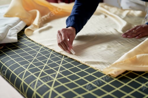 Preview: Close up tailor's hand drawing on the textile